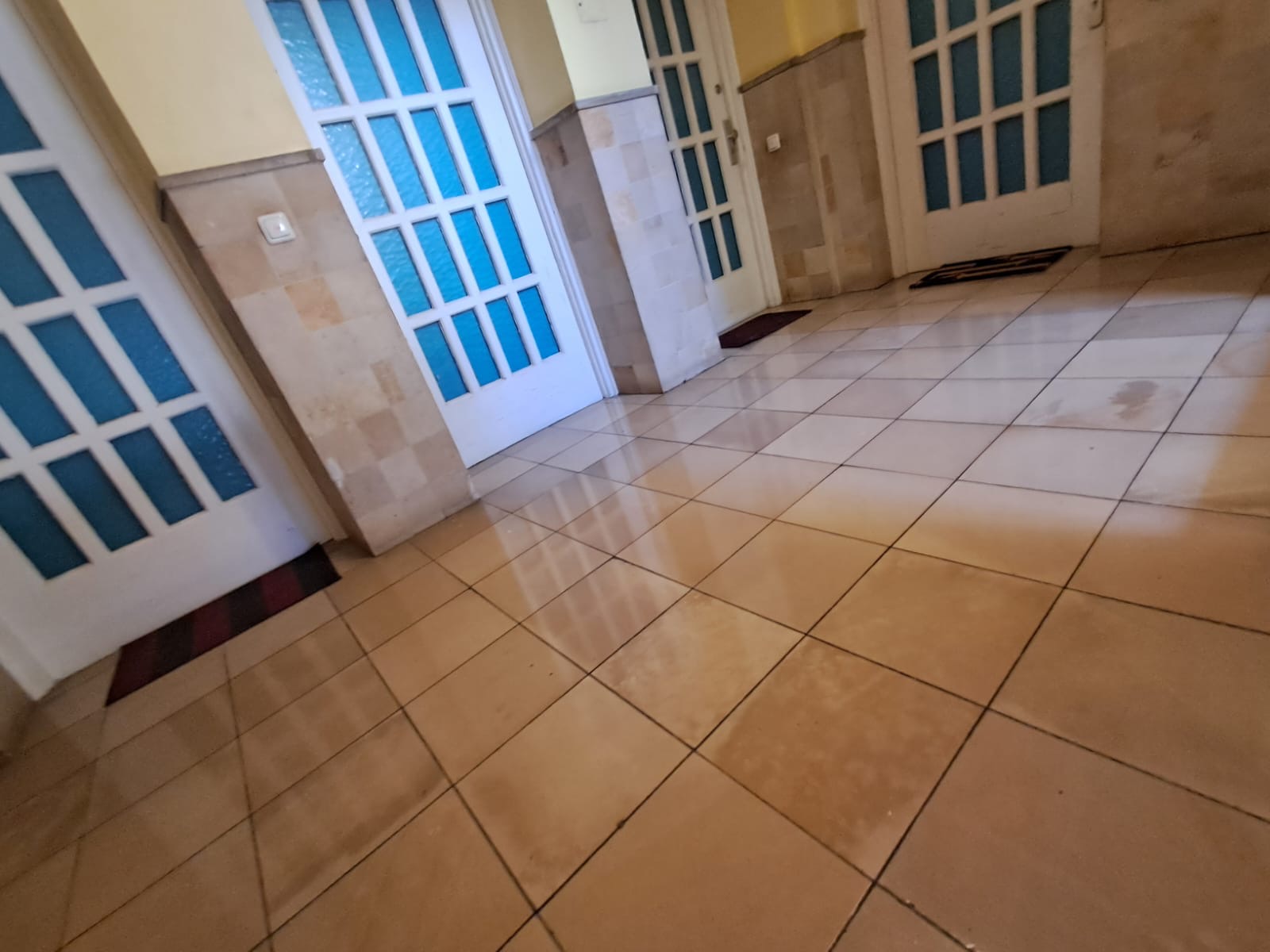 Frisch gereinigter Fliesenboden im Treppenhaus einer Wohnanlage
