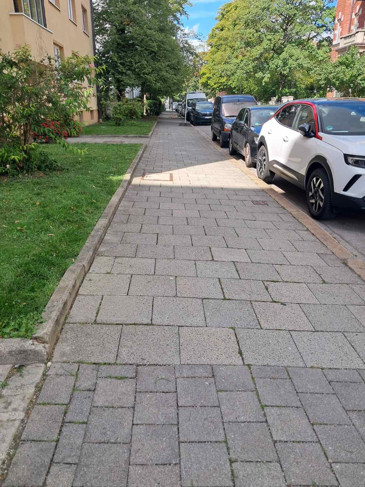 Gereinigter Gehweg entlang einer Wohnanlage